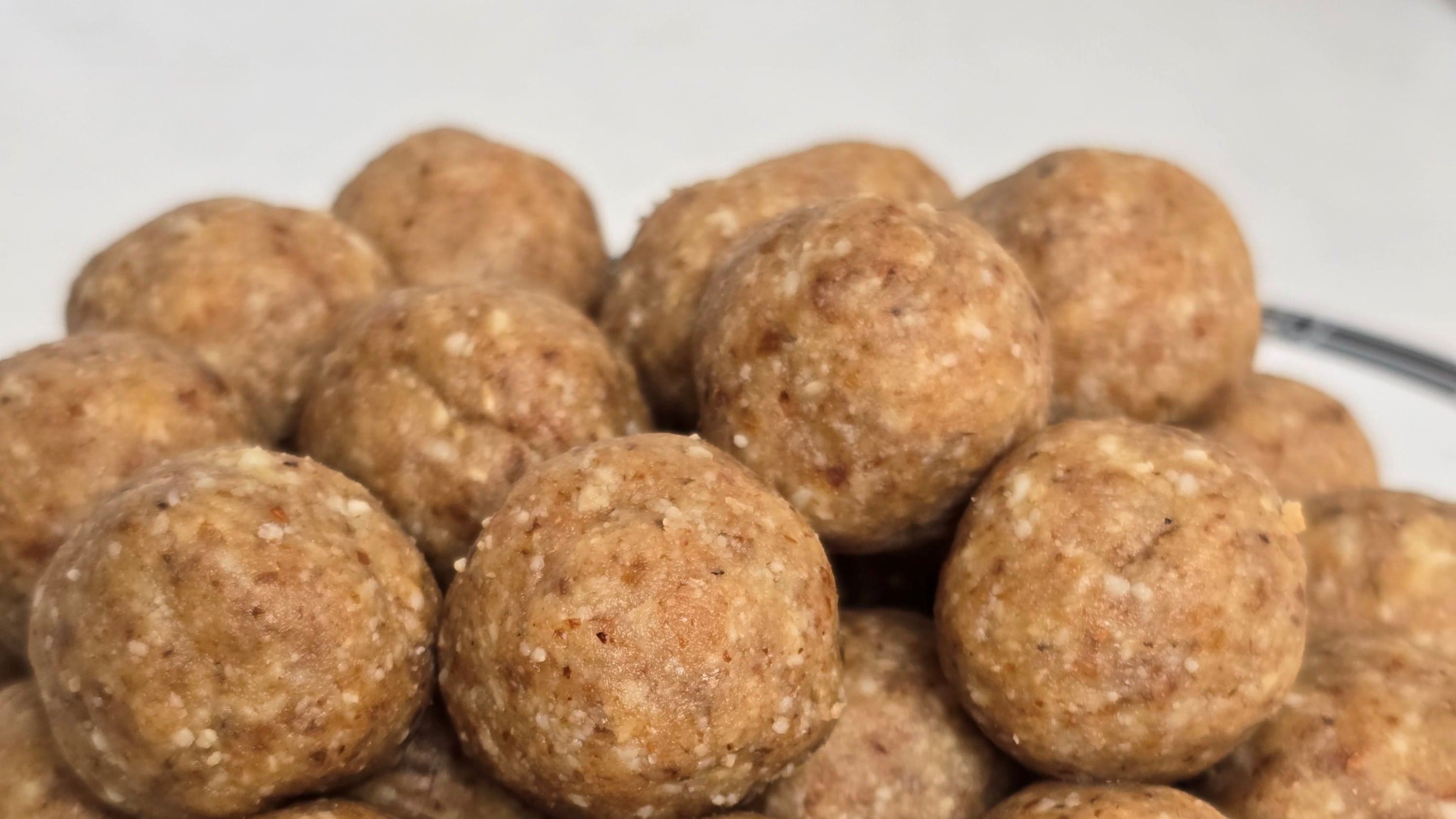 Classic Aum Bites — hand-rolled date and nut bites arranged in a loose cluster